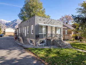 View of front of home with a mountain view and a front lawn