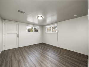 Spare room featuring dark wood-type flooring