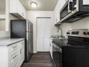 Kitchen featuring white cabinetry, sink, and stainless steel appliances