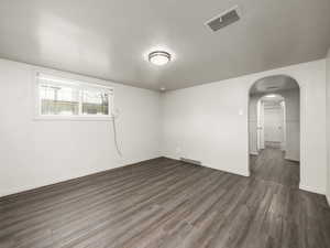 Spare room with dark wood-type flooring