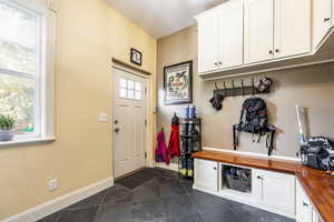 Mudroom with dark tile patterned floors and a healthy amount of sunlight