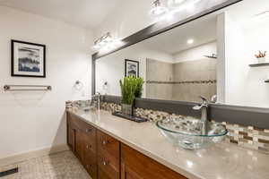 Bathroom with vanity and tasteful backsplash