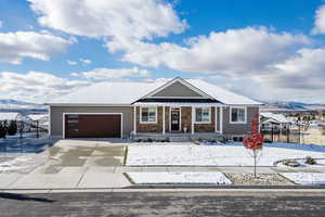 Single story home featuring a mountain view, a porch, and a garage