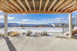 Snow covered patio with a mountain view