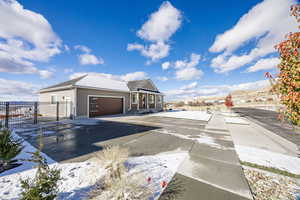 View of snowy exterior featuring a mountain view and a garage