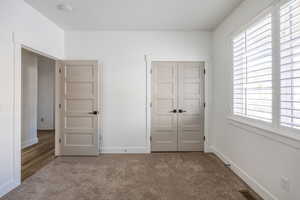 Unfurnished bedroom featuring medium colored carpet and a closet