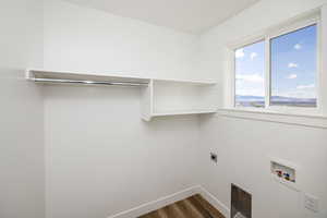 Laundry room with hookup for an electric dryer, dark wood-type flooring, and washer hookup