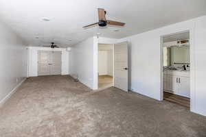 Unfurnished bedroom featuring sink, ceiling fan, medium colored carpet, and a textured ceiling