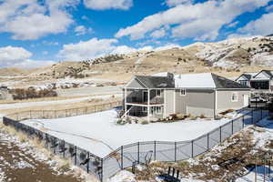 Snow covered property with a mountain view and a balcony