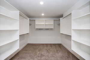 Spacious closet with medium colored carpet