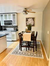 Dining area with ceiling fan and light hardwood / wood-style floors