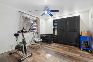 Workout room featuring dark hardwood / wood-style flooring and ceiling fan