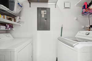 Washroom featuring electric panel and washer and dryer