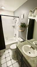 Full bathroom with toilet, vanity, and tiled shower / bath