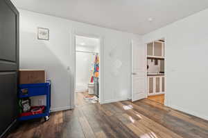 Bedroom featuring ensuite bathroom, dark wood-type flooring, and sink