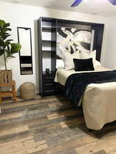 Bedroom featuring ceiling fan and dark hardwood / wood-style flooring