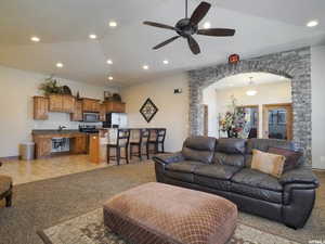 Living room featuring ceiling fan and lofted ceiling