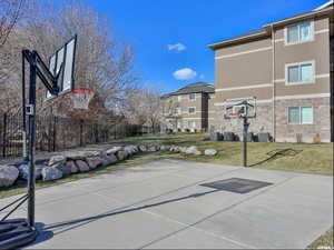 View of basketball court with a lawn