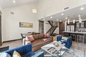 Living room with light wood-type flooring and high vaulted ceiling