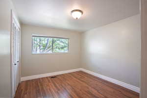 Empty room with dark hardwood / wood-style flooring