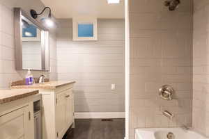 Bathroom featuring vanity and tiled shower / bath