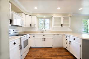 Kitchen with sink, dark hardwood / wood-style flooring, white appliances, white cabinets, and ornamental molding