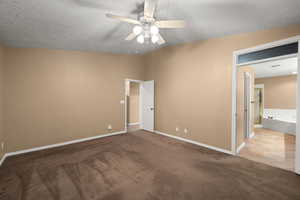 Unfurnished bedroom with lofted ceiling, ceiling fan, light carpet, and a textured ceiling