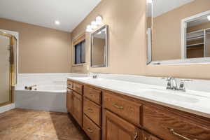 Bathroom featuring vanity and independent shower and bath