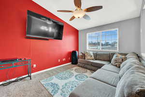 Living room with carpet, vaulted ceiling, and ceiling fan