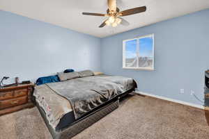 Carpeted bedroom with ceiling fan and a textured ceiling