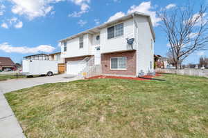 Raised ranch featuring a front yard and a garage