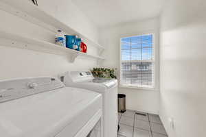 Laundry area featuring washer and clothes dryer and light tile patterned floors