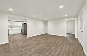 Unfurnished living room with sink and wood-type flooring