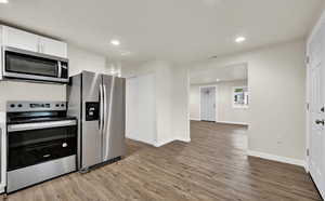 Kitchen featuring white cabinets, light hardwood / wood-style floors, and stainless steel appliances