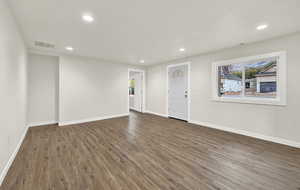 Empty room with dark hardwood / wood-style flooring