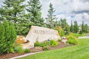 Community / neighborhood sign featuring a lawn