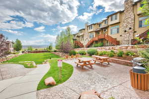 View of property's community featuring a lawn and a patio