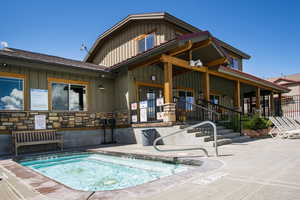 Rear view of property with a community hot tub