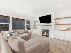 Carpeted living room with a tiled fireplace