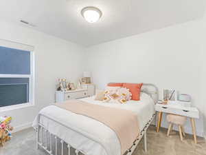 Bedroom featuring light colored carpet