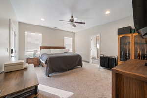 Carpeted bedroom with ceiling fan and ensuite bath