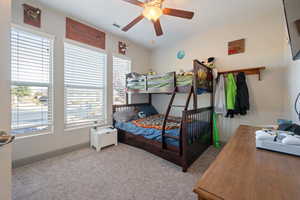 Carpeted bedroom featuring ceiling fan