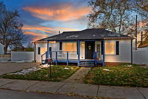 Bungalow-style home featuring a lawn and a porch