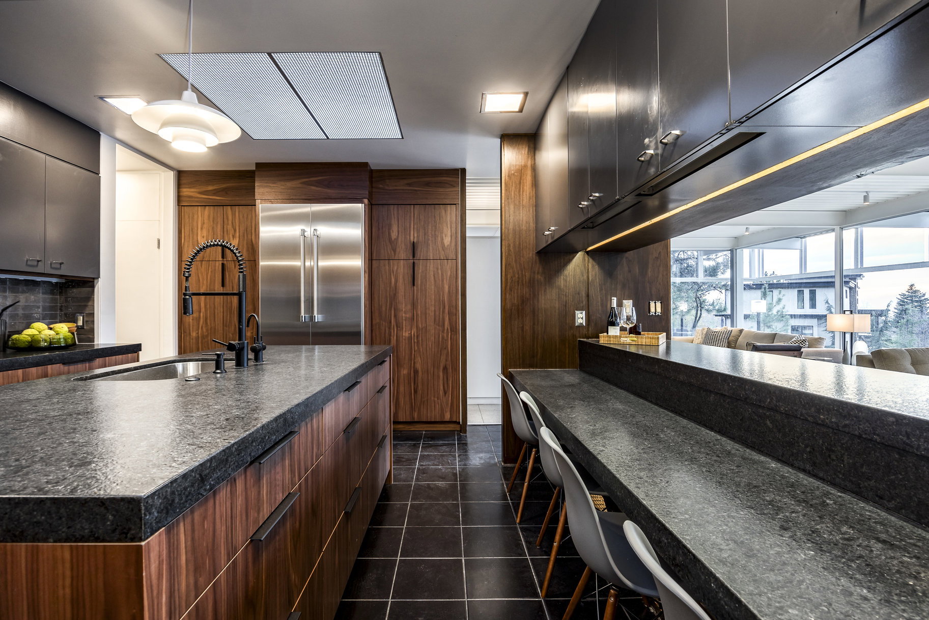 Kitchen with backsplash, stainless steel built in refrigerator, a kitchen island with sink, sink, and dark tile patterned flooring