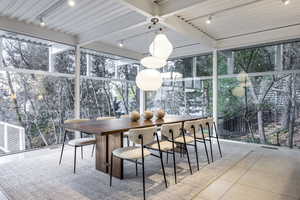 Sunroom / solarium with beamed ceiling and rail lighting