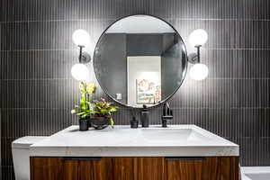 Bathroom featuring vanity and tile walls