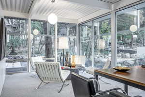 Sunroom featuring beamed ceiling and a healthy amount of sunlight