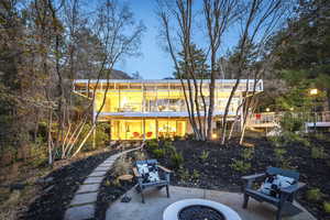 Rear view of property with a balcony, an outdoor fire pit, and a patio