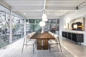 Sunroom / solarium with beam ceiling and a healthy amount of sunlight