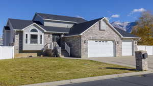 View of front of house featuring a mountain view, a garage, and a front yard